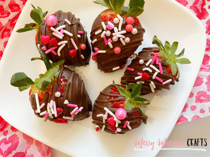 A plate of chocolate covered strawberries with Valentine's Day sprinkles.