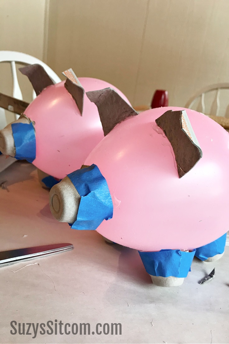 A balloon and egg carton pig shape taped together.