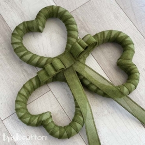 Green Shamrock Wreath layed out on a wood background.