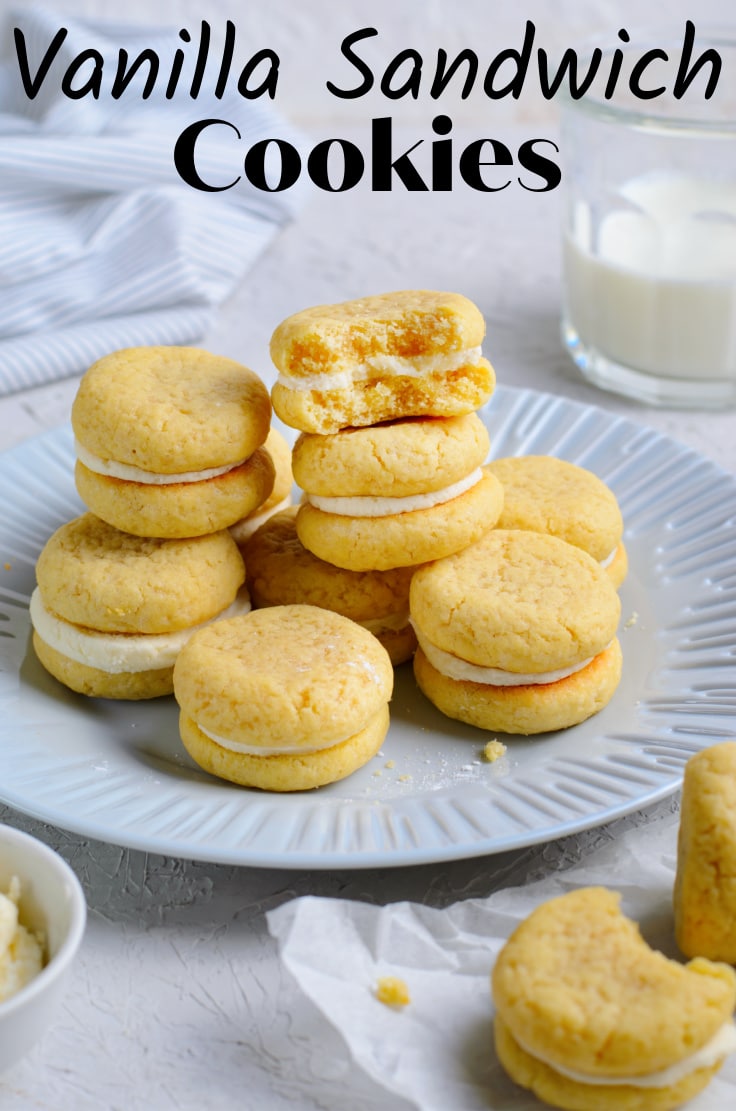A plate full of vanilla sandwich cookies with cream filling.