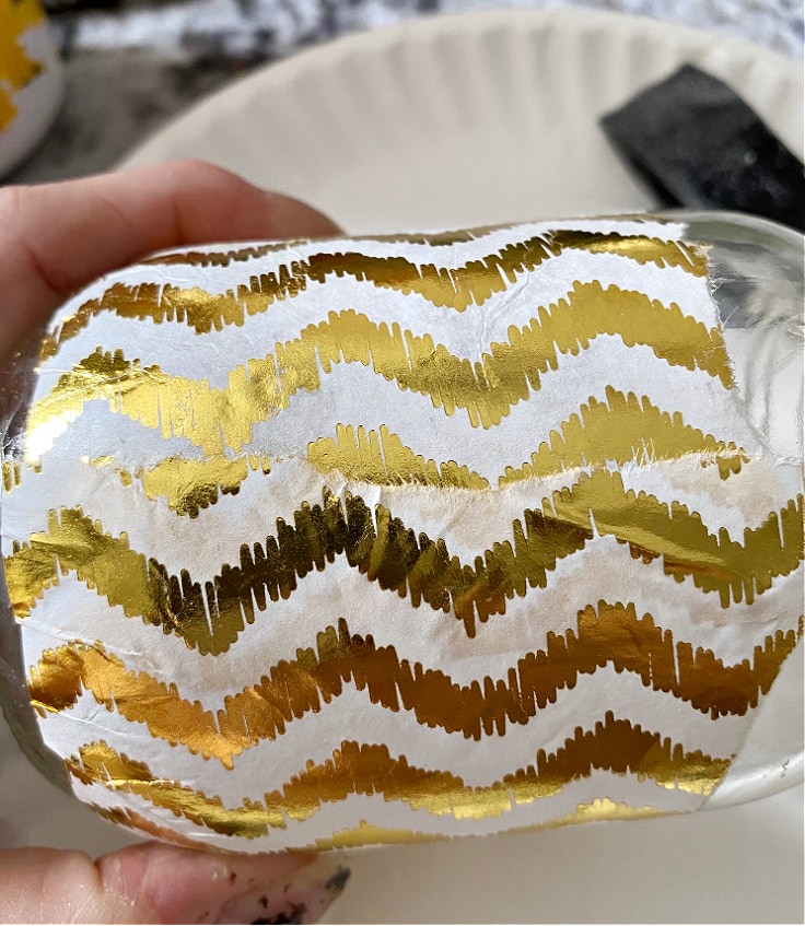 Mason jar with gold and white stripes.