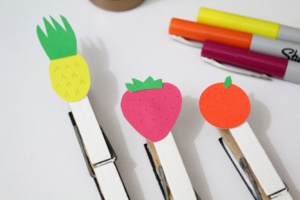 Paper fruit attached to clothespins.