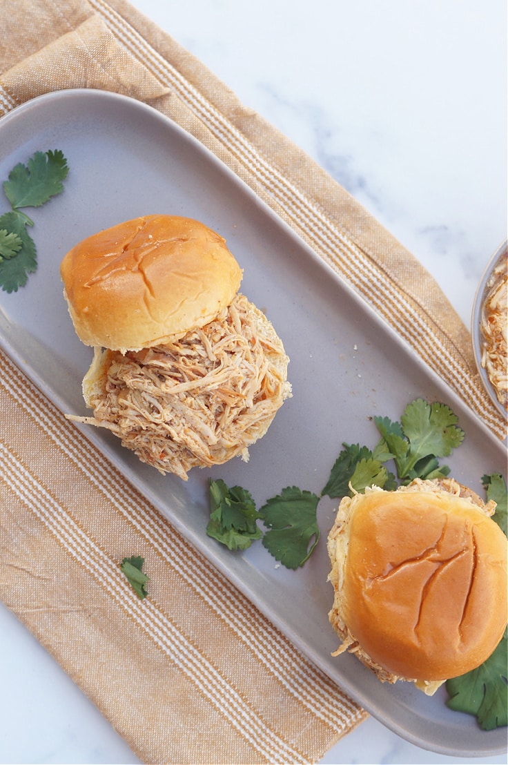 Overview of shredded chicken on a white bun.