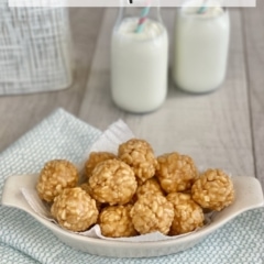 Peanut Butter Rice Krispies Bites in a white dish with two bottles of milk in the background.