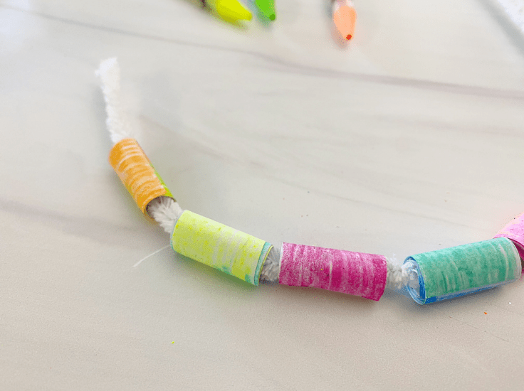 String the paper beads onto a piece of pipe cleaner.