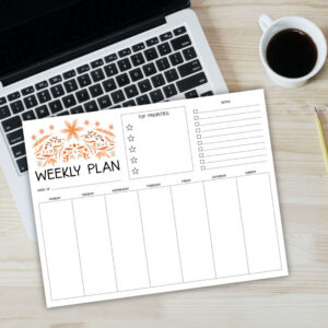 Preview of printed weekly planner page on top of laptop with cup of coffer in upper right hand corner.