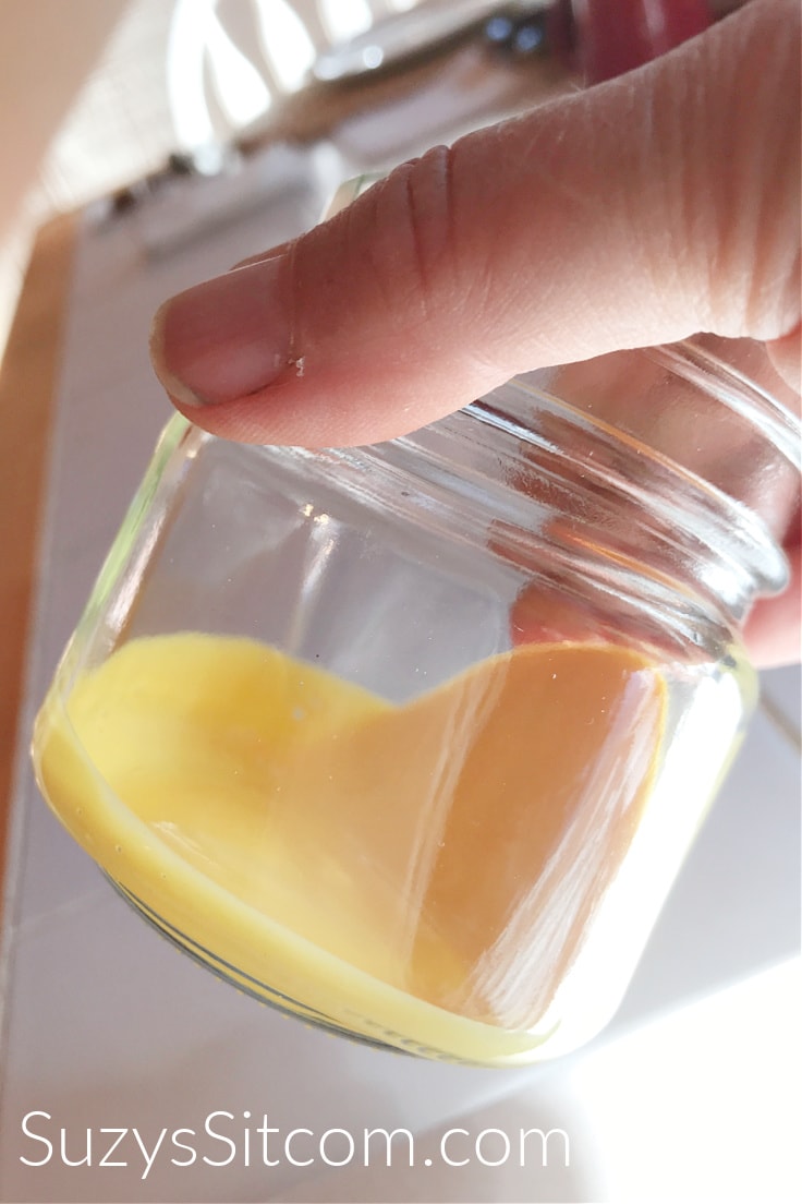 Swirling yellow mod podge around the inside of a glass mason jar