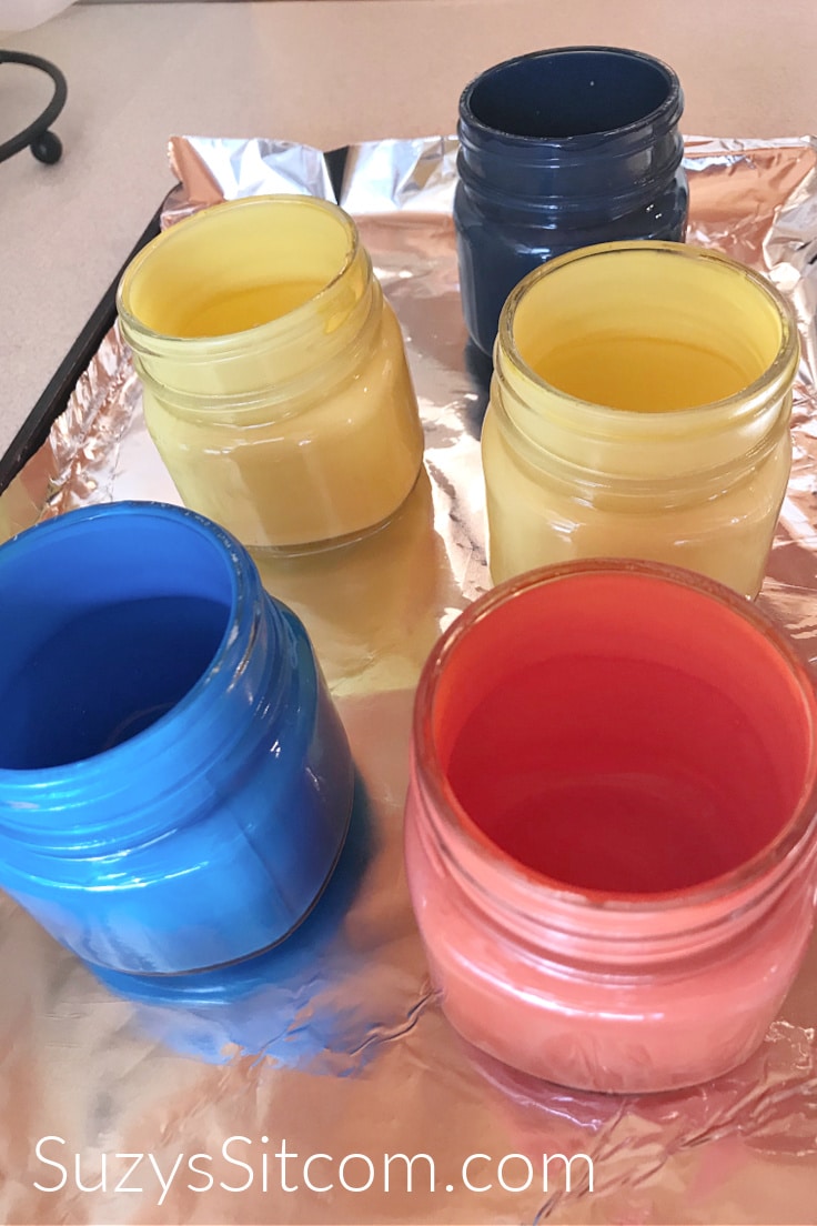 Colored mason jars drying on a baking sheet 