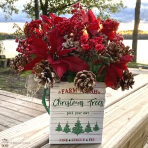 Christmas gift box with poinsettias and pine cones