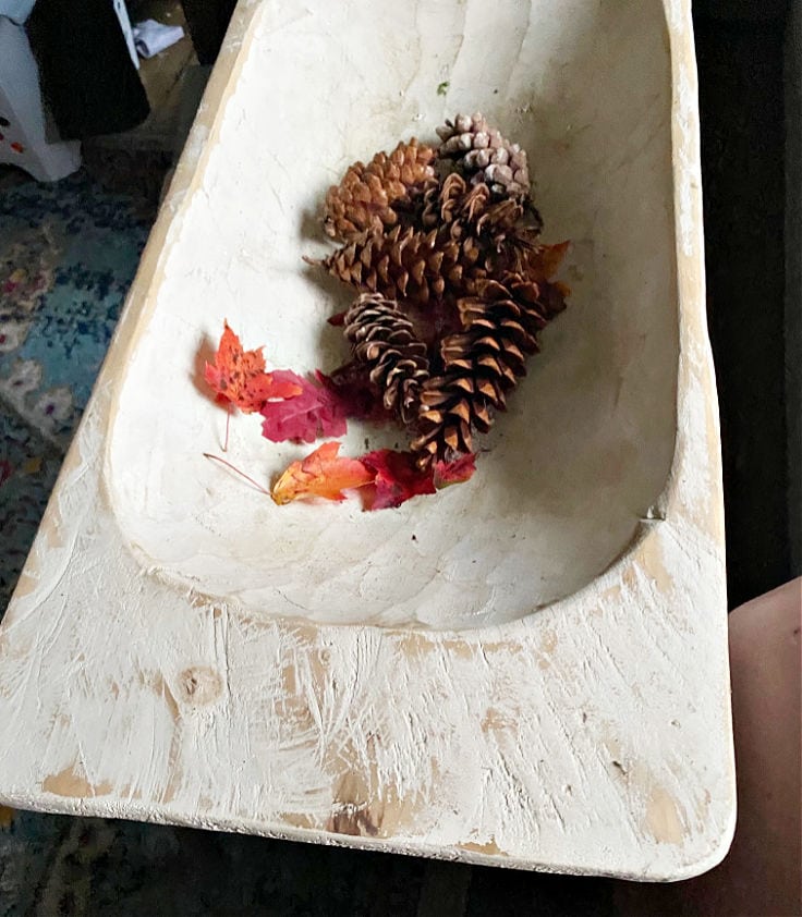 Pinecones in a wooden dough bowl.