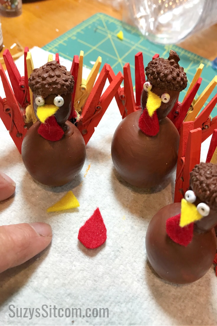 Adding faces to the DIY turkeys for the Thanksgiving place settings