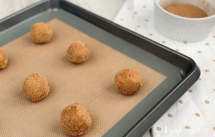 Pumpkin Spice Snickerdoodle Cookie dough balls on a baking sheet ready for the oven.