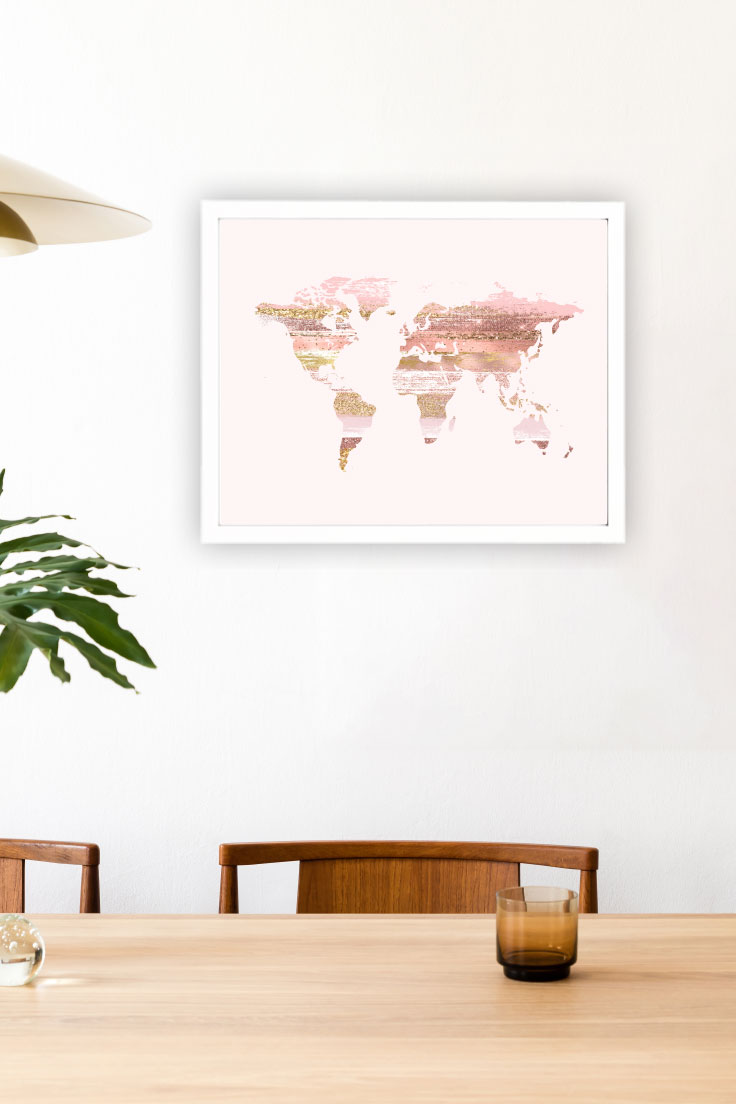 Preview of pink glitter world map design in a white frame on kitchen wall behind wooden table.