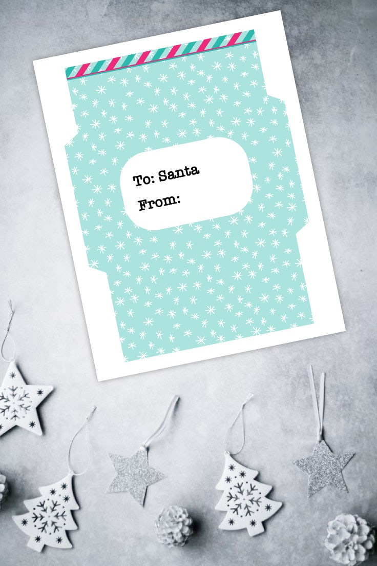 Preview of coordinating envelope printable on grey surface with white holiday ornaments on the bottom.