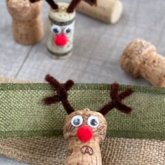 Upcycled wine corks turned reindeer on a wood backdrop.