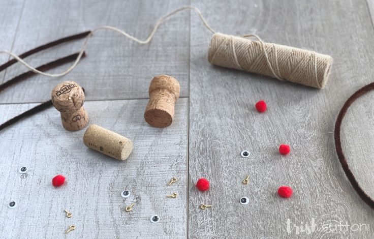 Reindeer Ornament supplies including wine corks, brown pipe cleaners, googly eyes, red felt and jute.