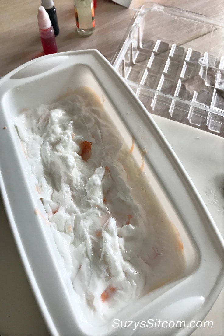 Mixing the white melted soap as a second layer on the orange soap