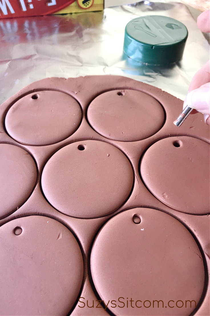 Cutting out little holes in the top of the clay circles 