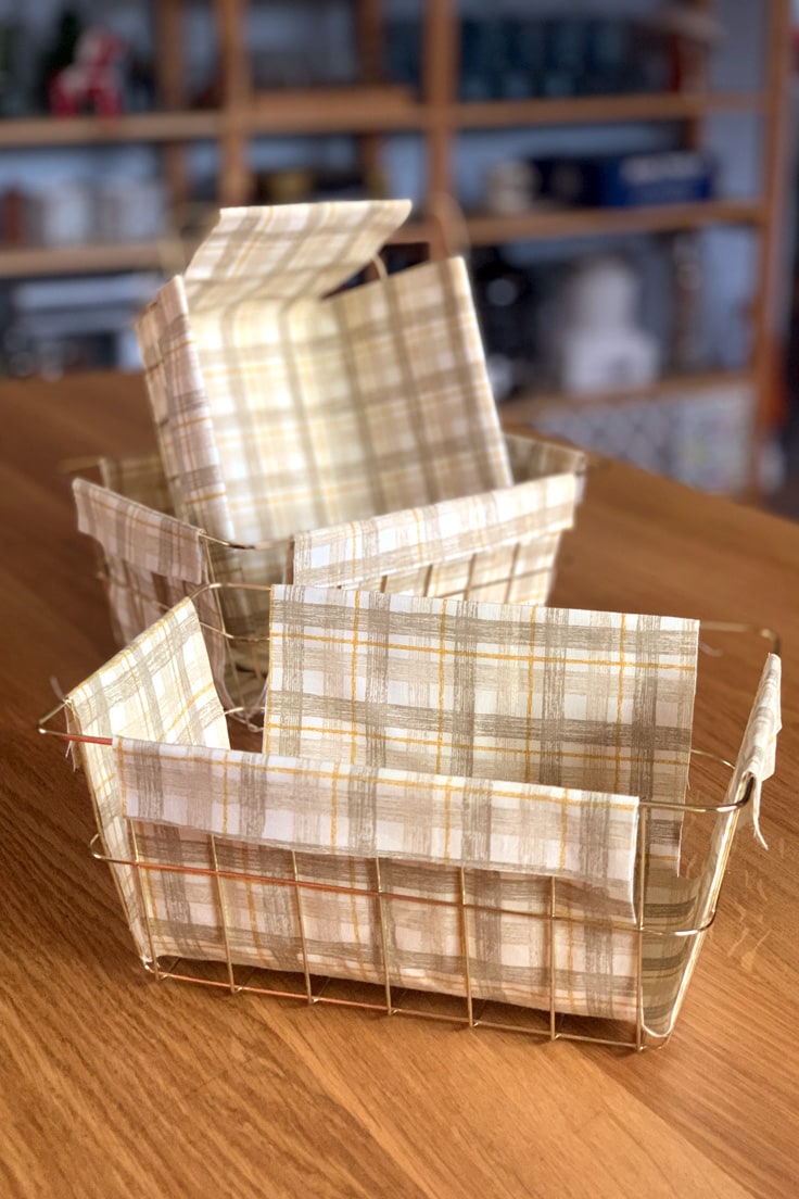 Gold wire baskets with gold plaid fabric liners.