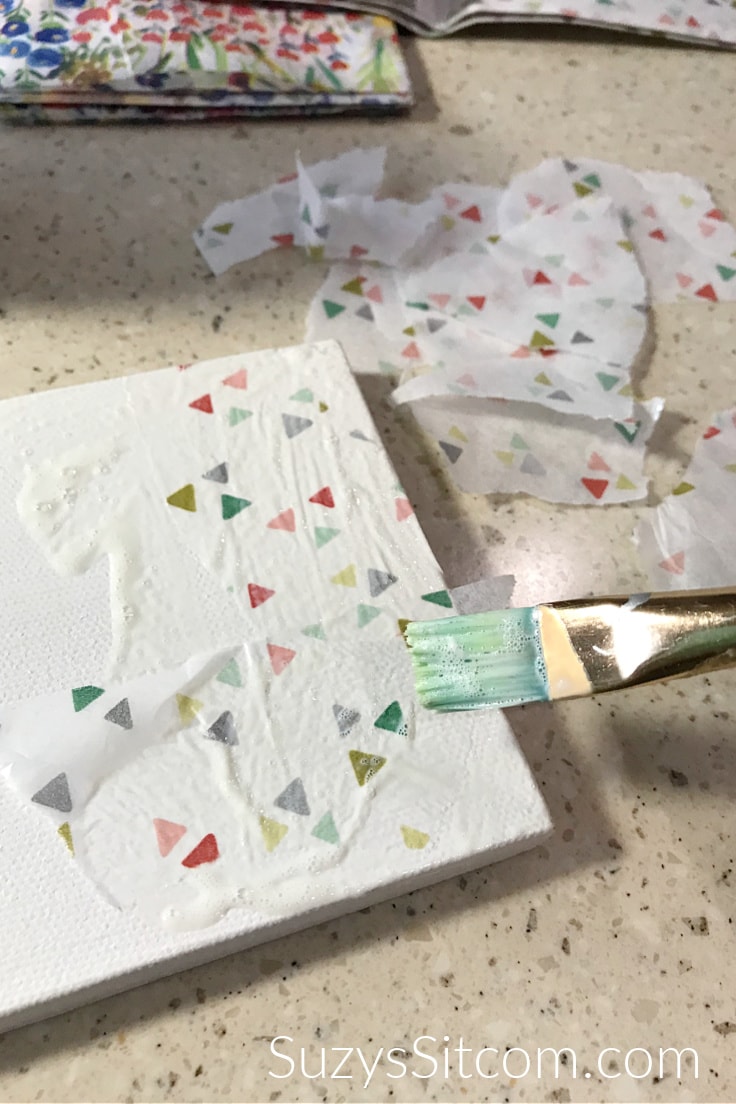 Adding paper to canvas with Mod Podge 