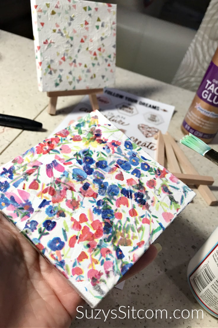 A canvas with floral paper glued to it as a background 