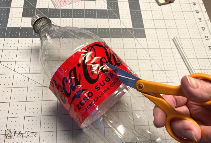Cutting the label off of a 2-liter bottle of Coca-Cola 