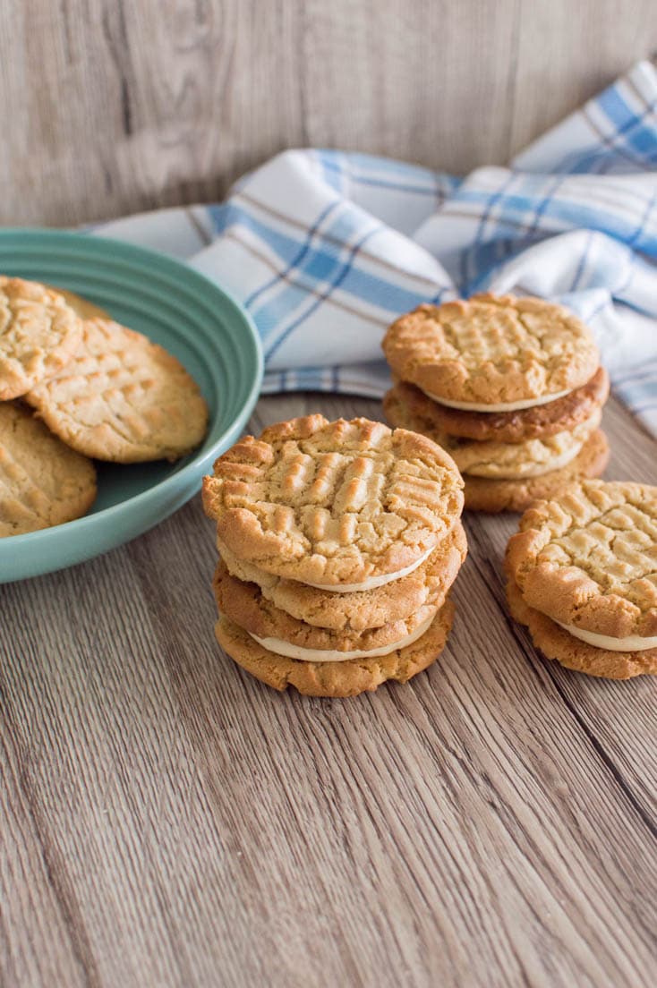 A stack of Peanut Butter Sandwich Cookies next to a mint green bowl.