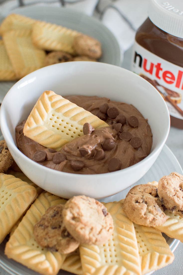 Dipping a shortbread cookie into a bowl of Nutella cookie dip