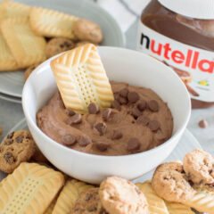 Dipping a shortbread cookie into a bowl of Nutella cookie dip