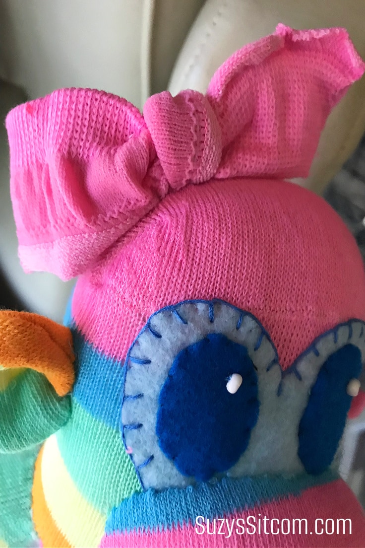 Adding the hairbow to a handmade sock monkey.