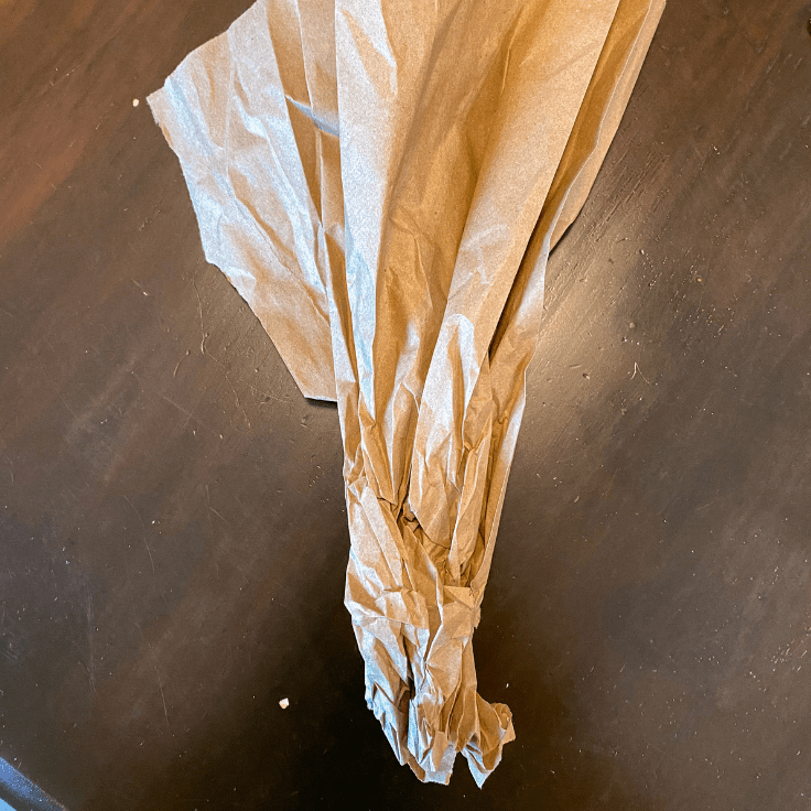 Brown paper bag crinkles at the bottom and the top is flared outward.