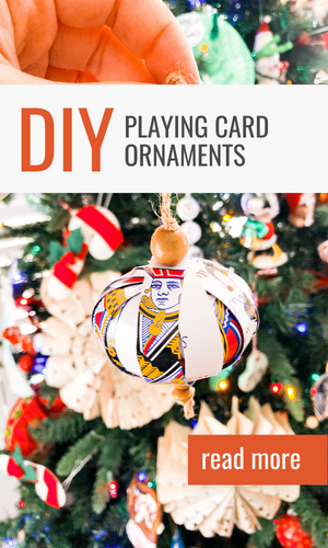 playing card ornament being held in front of a tree
