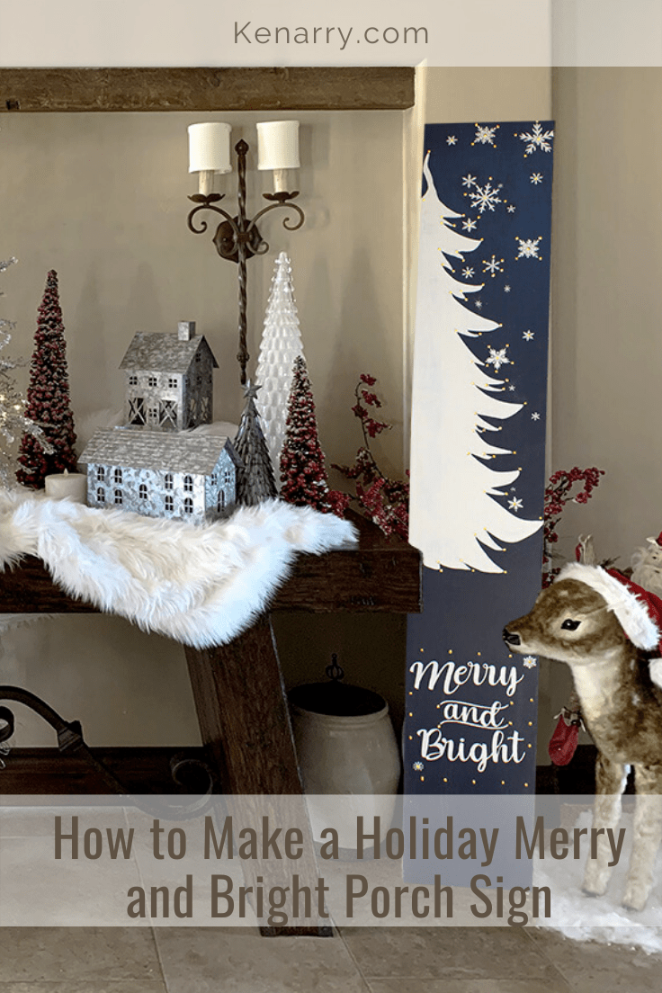 Blue and white porch sign painted with a tree, snowflakes, and the words 
