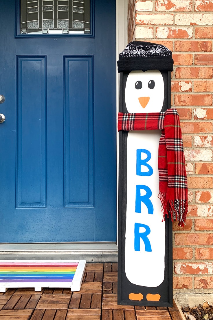 A winter porch sign that resembles a penguin in winter hat and scarf and BRR down its front.