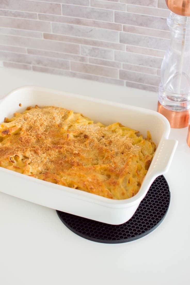 Mac and cheese made out of egg noodles and baked in a white casserole dish