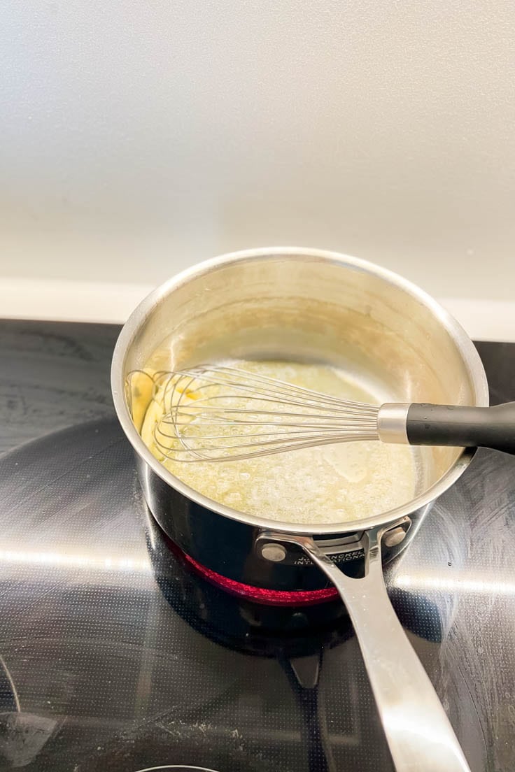 Melting butter and whisking it in a saucepan
