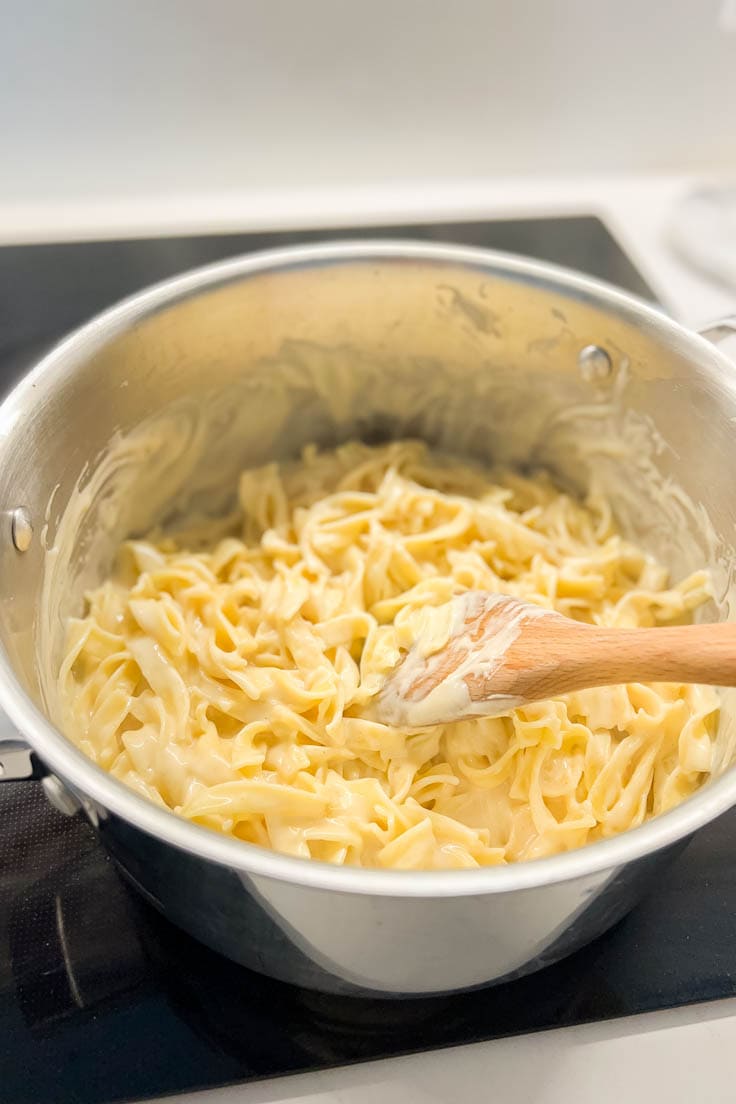 Cheese mixture poured into a large pot of egg noodles