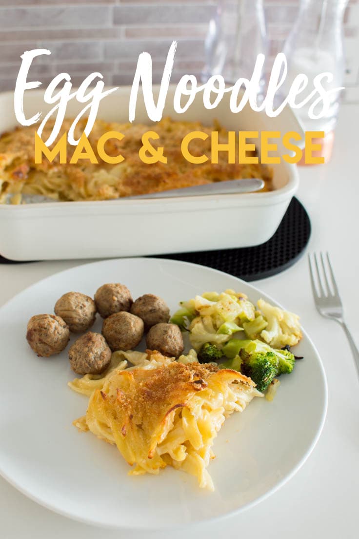 Egg Noodles Mac and Cheese served on a white plate with meatballs and roasted vegetables