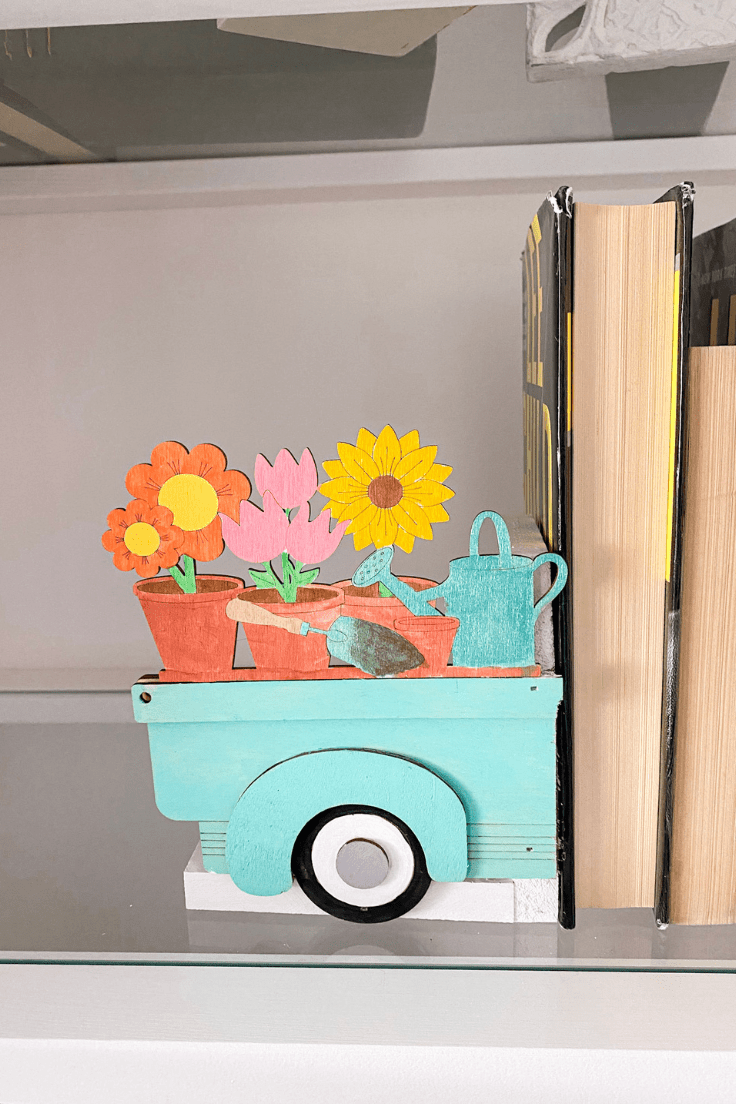 wood truck bed with flowers and watering can in it holding up books
