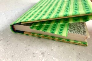 Fabric folded over the front cover of a book with extra fabric folded back.