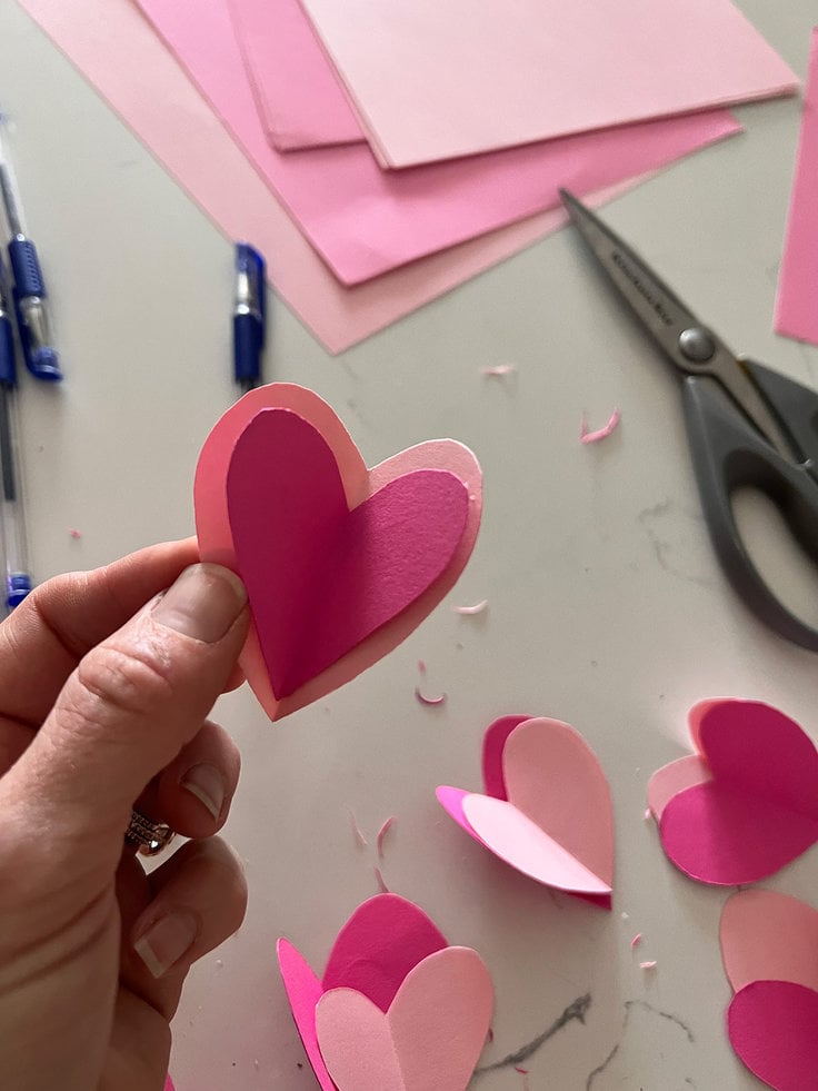 place one of the smaller hearts inside one of the larger hearts and attach them together with hot glue.
