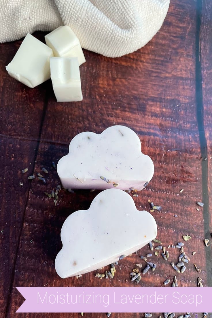 lavender cloud shaped soap on dark boards with dried lavender sprinkled around it