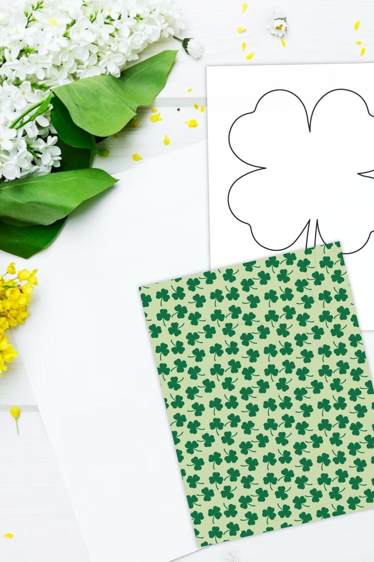 Preview of four leaf shamrock shape and green shamrock patterned paper on a white background with leaves and flowers in the upper left corner.