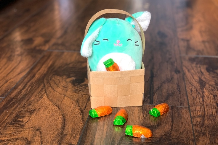 DIY Easter basket with a green Squishmallow bunny and chocolate candy carrots.