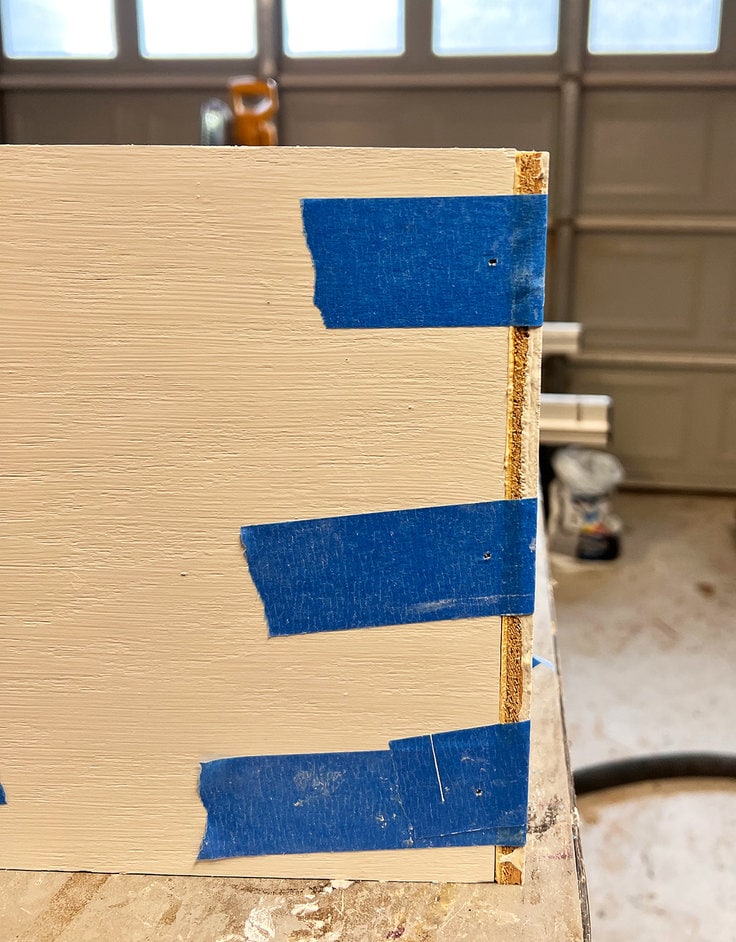 nails and tape secure the lap joint on the shadow box shelves while the wood glue cures.