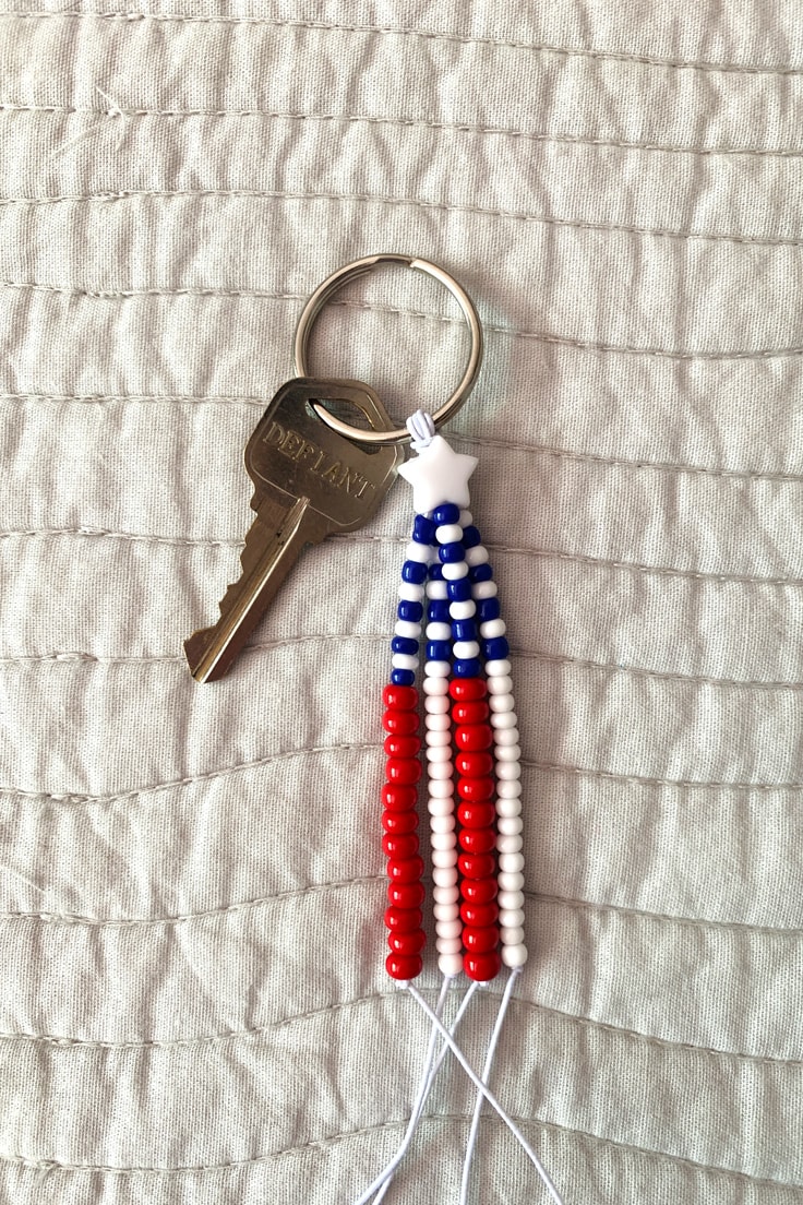 Small keychain made from red, white and blue beads in a stripe pattern to resemble the American flag.