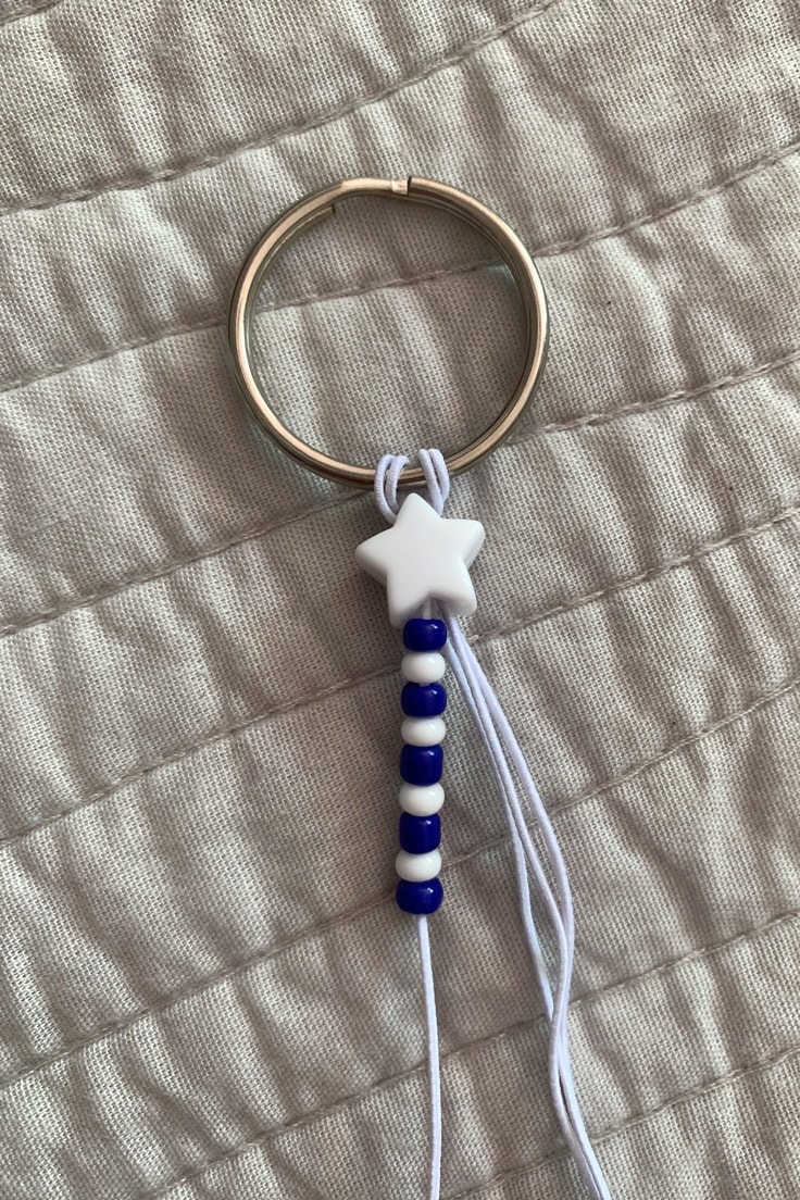 Alternating blue and white beads threaded onto cord beside a star.