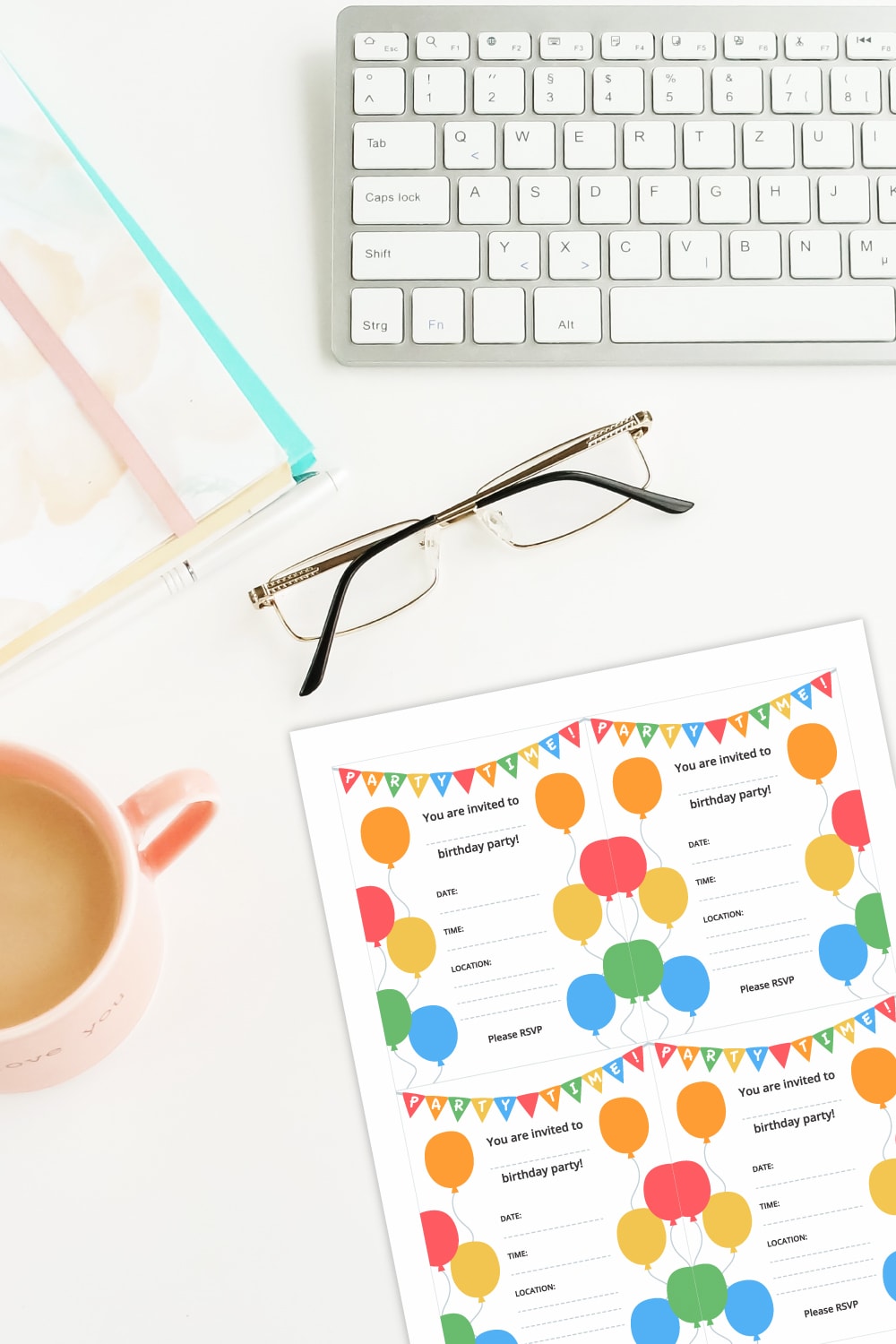 Preview of birthday party invite printable page on white desk with keyboard on top edge, stationery items, glasses and partial view of coffee mug on the left side. 
