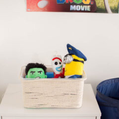 An easy-to-make DIY Rope Basket sitting on a side table, filled with toys
