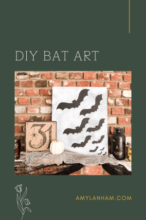 a picture with bats flying next to some halloween decor sitting on a brick mantel